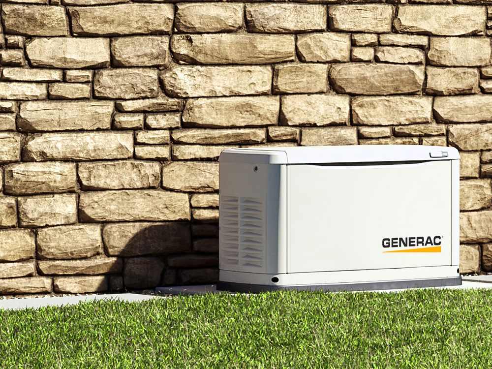 Generac standby generator installed beside a stone-clad home